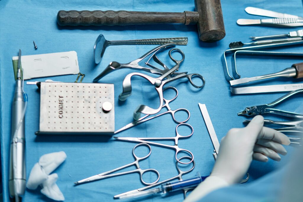 pexels-photo-7585026-7585026 Close-up of various surgical instruments on a blue sterile sheet in a medical setting.