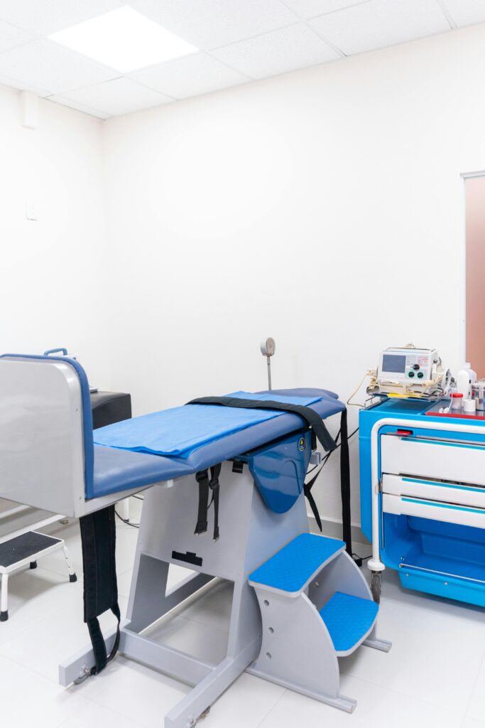pexels-photo-8460220-8460220 Clean and well-equipped hospital examination room with blue medical equipment and diagnostic devices.